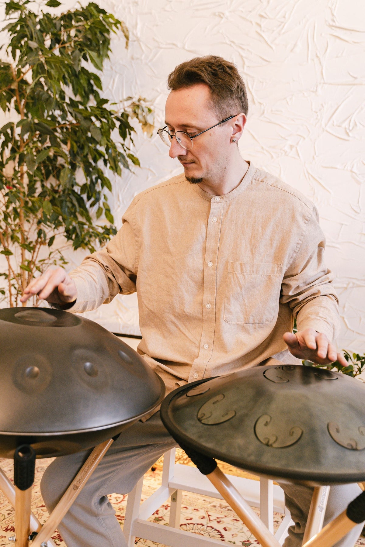 Musicien jouant de deux handpans à la maison