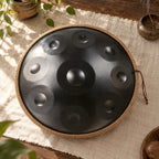 Schwarzes Handpan Nuit mit geflochtenem Schutzband auf einem Tisch