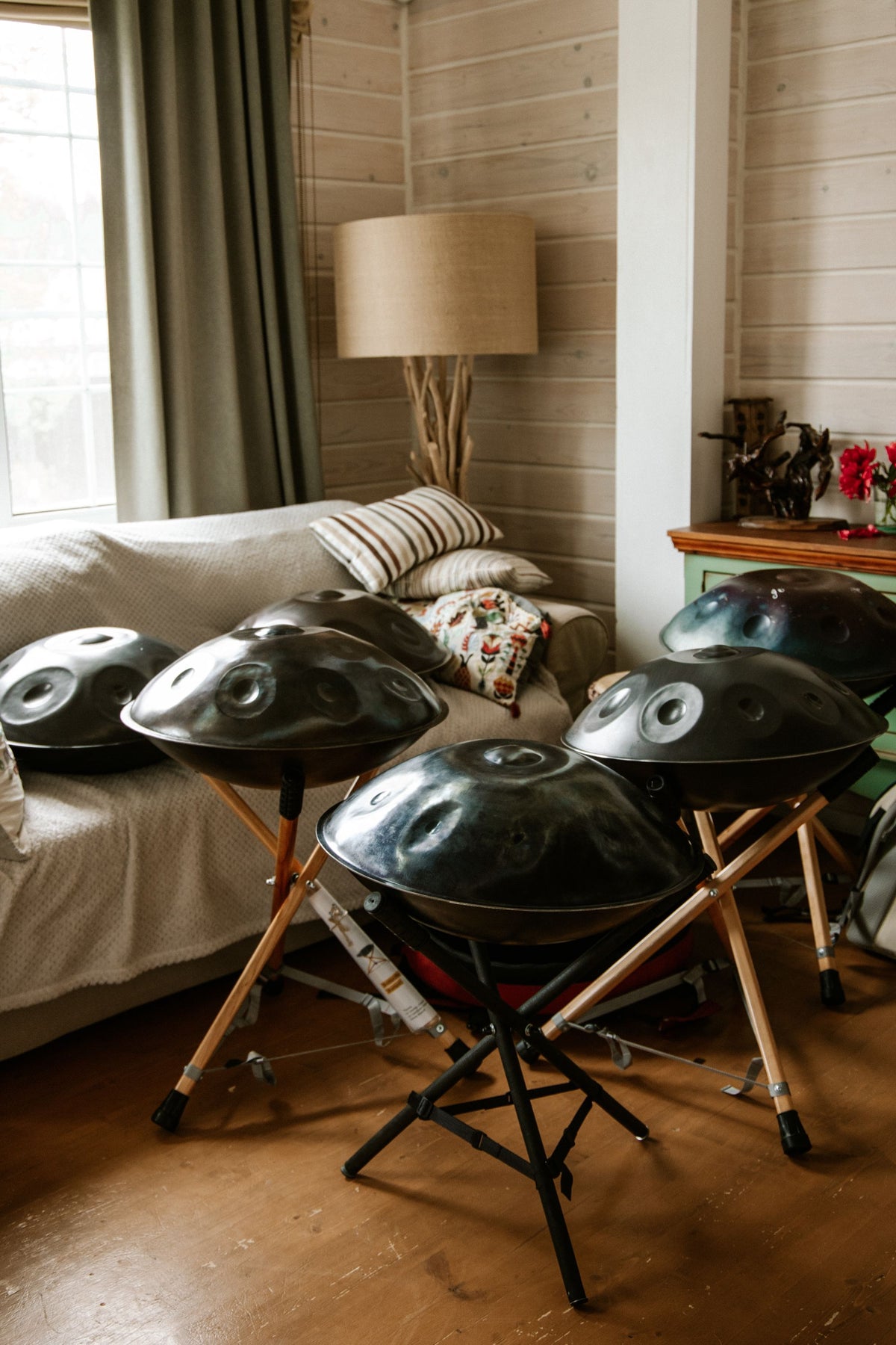 Plusieurs handpans sur leurs supports dans un salon