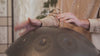Mains posées sur un handpan
